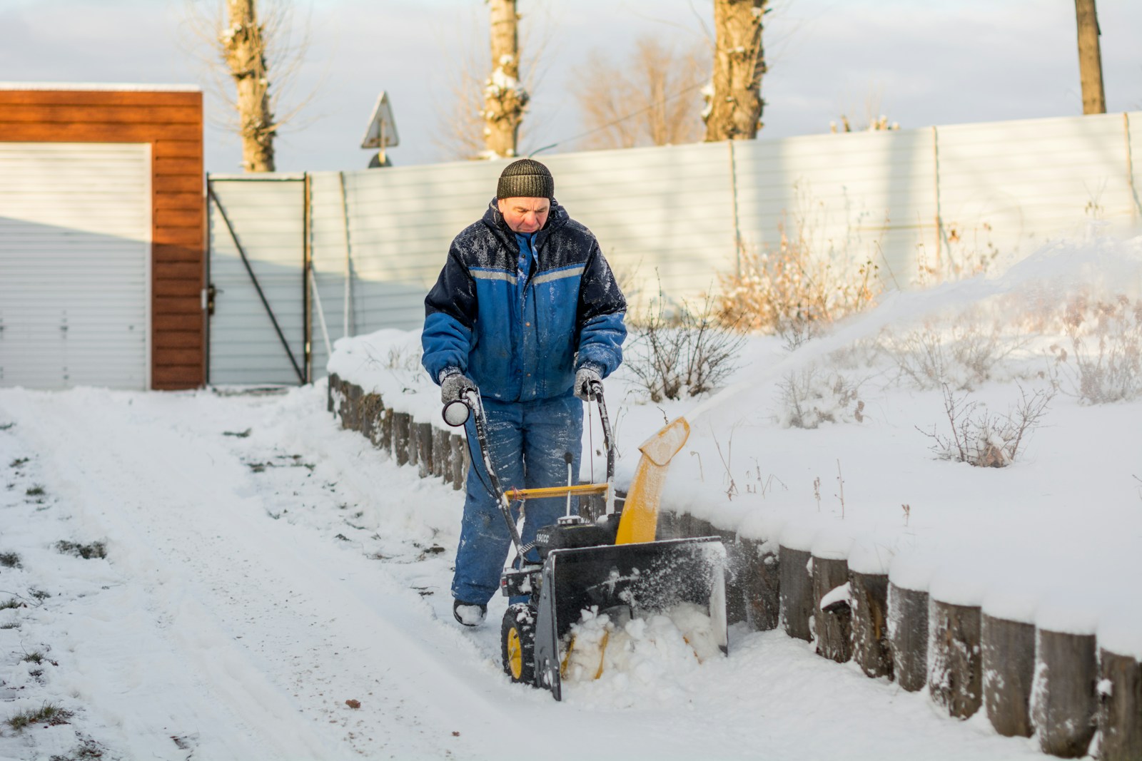 a man shoveling snow with a snow blower